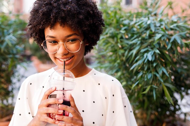 Photo une adolescente souriante buvant un verre