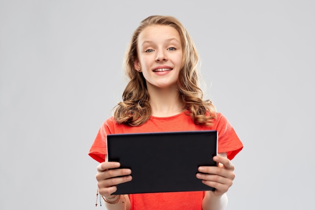 une adolescente souriante avec une tablette