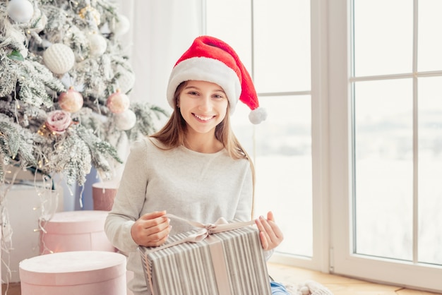 Adolescente souriante tenant le cadeau de Noël