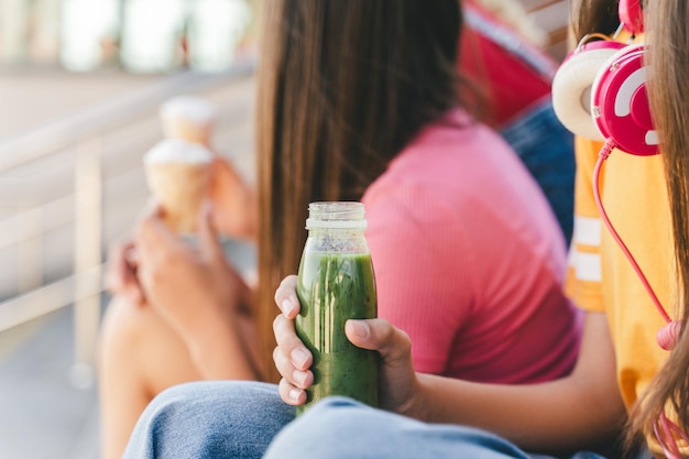 une adolescente en T-shirt coloré tenant une boisson rafraîchissante de limonade dans une rue urbaine