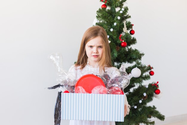 Une adolescente tenant un arbre de Noël