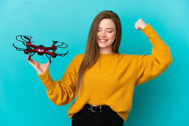 Adolescente tenant un drone sur fond bleu isolé faisant un geste fort