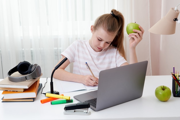 Adolescente, tenue, pomme verte, étudier, chez soi, à, ordinateur portable