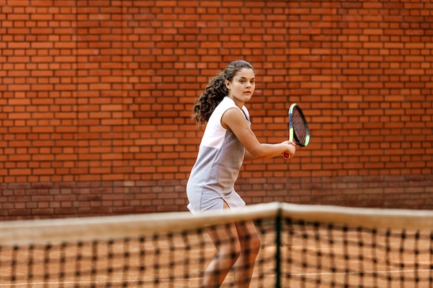 Adolescente en tenue sportive jouant au tennis