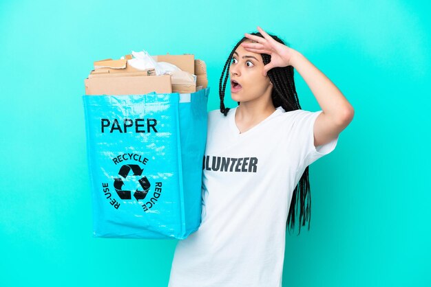 Adolescente avec des tresses tenant un sac à recycler avec une expression surprise tout en regardant de côté