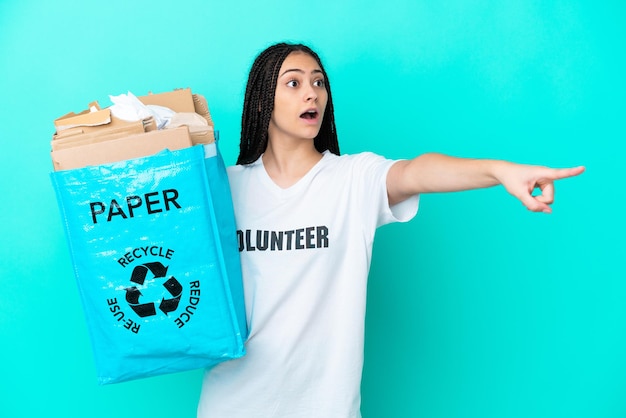 Adolescente avec des tresses tenant un sac à recycler pointant vers l'extérieur