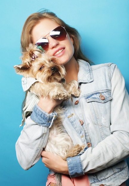 Adolescente avec Yorkshire Terrier sur fond bleu