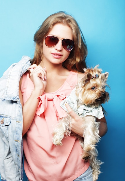 Adolescente avec Yorkshire Terrier sur fond bleu