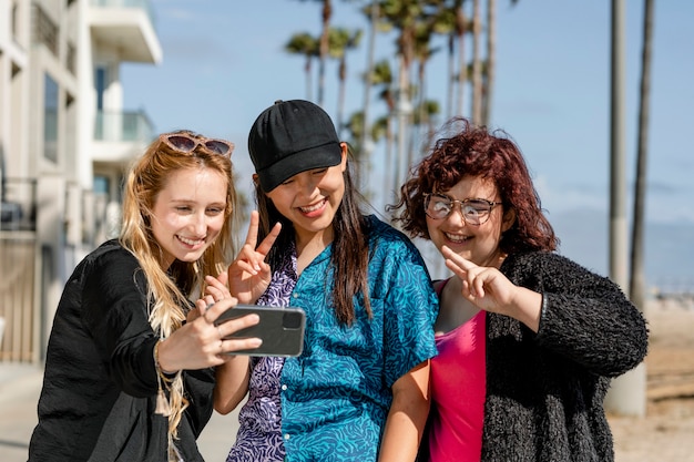 Adolescentes prenant selfie, profitant de l'été ensemble à Venice Beach, Los Angeles