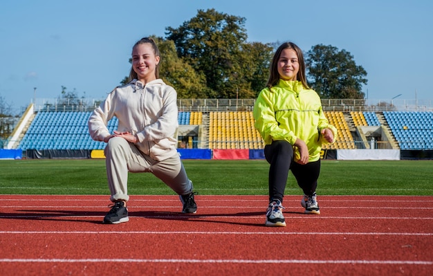 Les adolescentes s'échauffent avant de s'entraîner et de courir sur la santé du stade en plein air