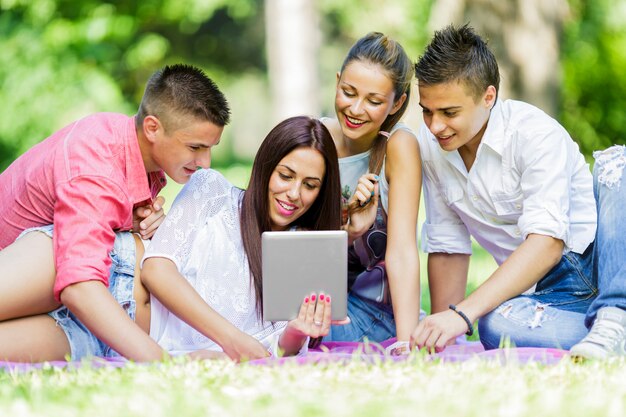 Adolescents dans le parc avec tablette