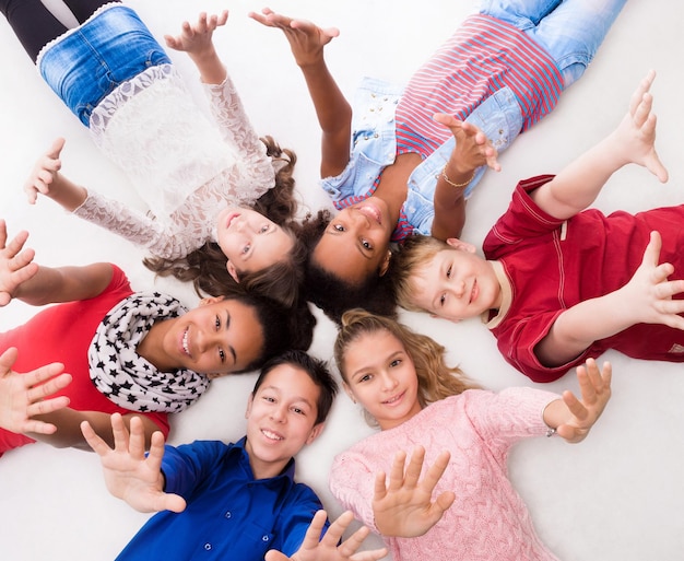 Des adolescents joyeux allongés sur le sol.