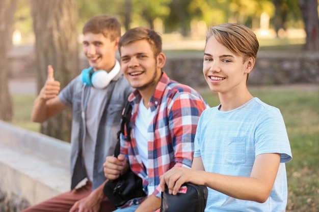 Adolescents mignons assis sur un parapet à l'extérieur