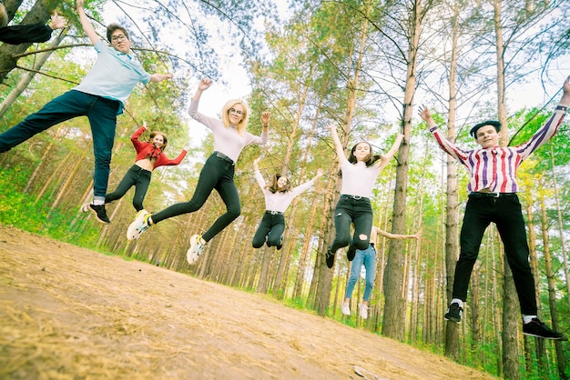 Adolescents sautant dans une ambiance ludique dans la forêt d'été