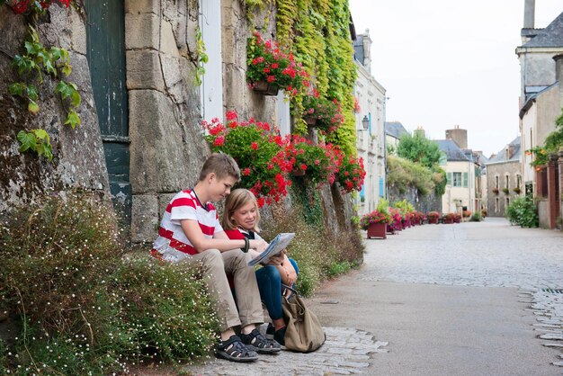 Les adolescents voyagent avec la carte dans la rue d'une vieille ville RochefortenTerre France Europe