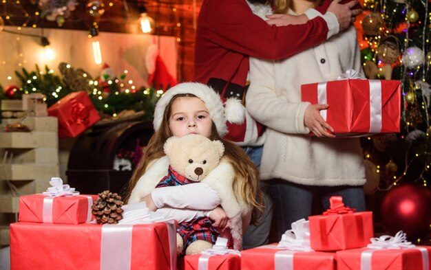 Adopter un enfant Souvenirs de Noël Moments heureux Fille à la maison le soir de Noël Enfant célèbre le nouvel an avec une pile de cadeaux Traditions de Noël Charité et gentillesse Faire le bien Se sentir aimé