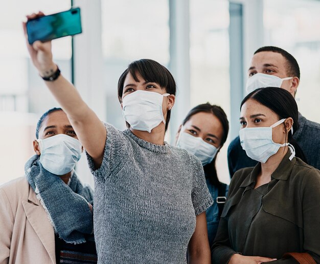 Adoptez une nouvelle normalité Photo d'un groupe de jeunes portant des masques et prenant des selfies à l'aéroport