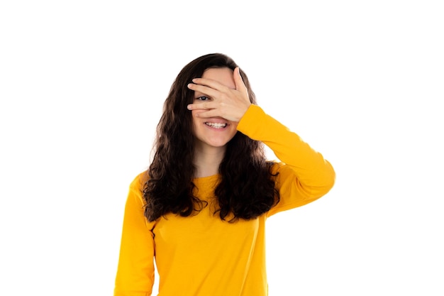 Adorable adolescente avec pull jaune isolé sur un mur blanc