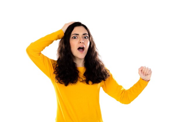 Adorable adolescente avec pull jaune isolé sur un mur blanc