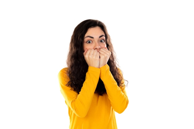 Adorable adolescente avec pull jaune isolé sur un mur blanc