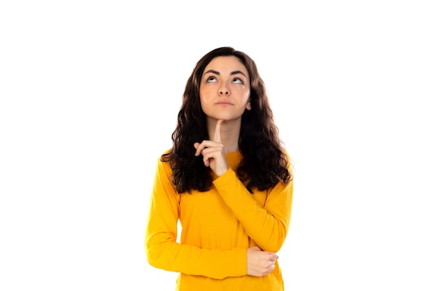 Adorable adolescente avec pull jaune isolé sur un mur blanc