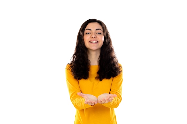 Adorable adolescente avec pull jaune isolé sur un mur blanc