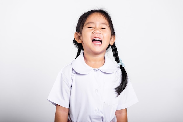 Adorable bambin asiatique souriant heureux portant l'uniforme thaïlandais étudiant debout