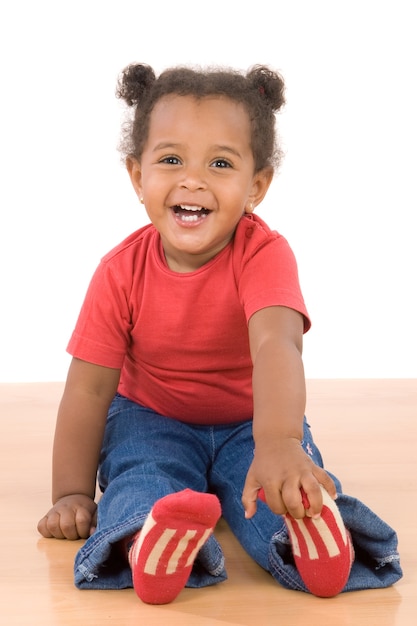 Adorable bébé africain assis sur un plancher en bois