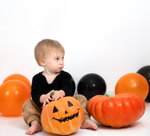 Adorable bébé caucasien blond avec bébé décoration citrouille célébrer le jour d'HalloweenCopy space