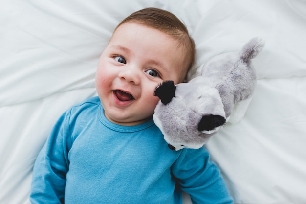 Adorable bébé avec un chien en peluche à ses côtés