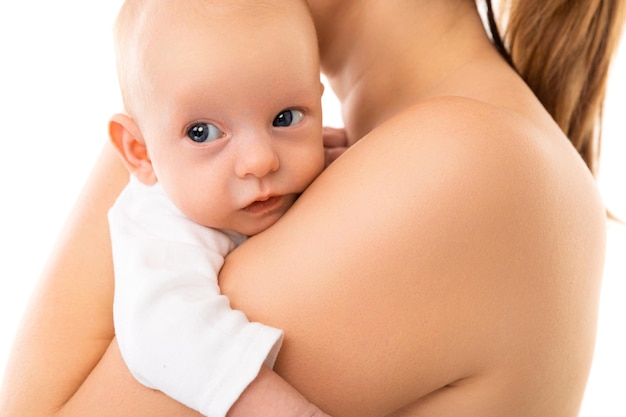 Adorable bébé gros plan sur la poitrine de la mère sur fond blanc