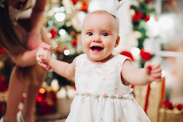 Adorable bébé heureux en robe blanche de fête à Noël