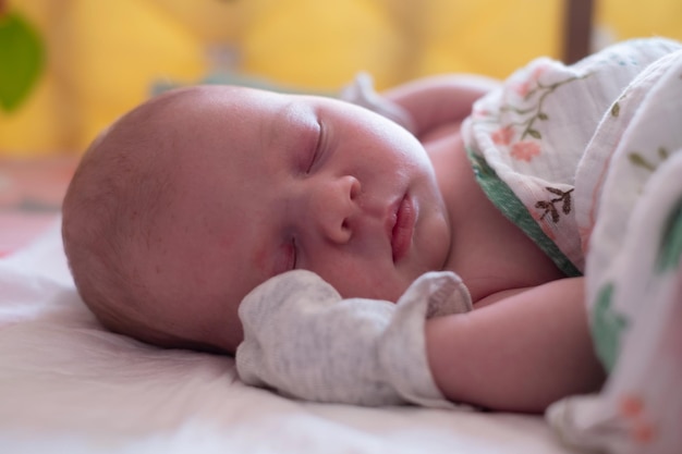 Adorable bébé nouveau-né caucasien dormant dans son lit en gros plan