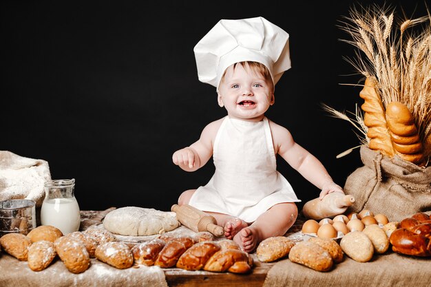 Adorable bébé sur la table avec de la pâte