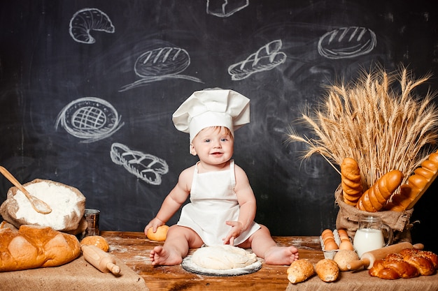 Adorable bébé sur la table avec de la pâte