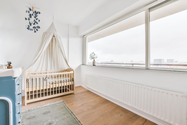 Adorable chambre bébé avec petit berceau en bois