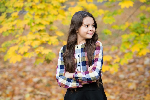 Adorable enfant aux cheveux longs, profitez de la nature automnale, de la saison.