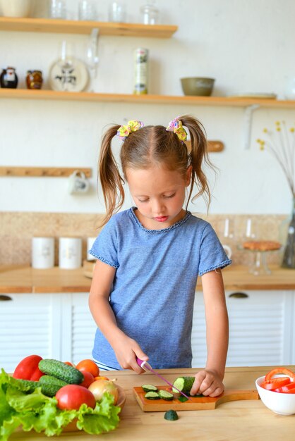 Adorable enfant cuisine dans la cuisine Jolie jolie fille prépare la soupe