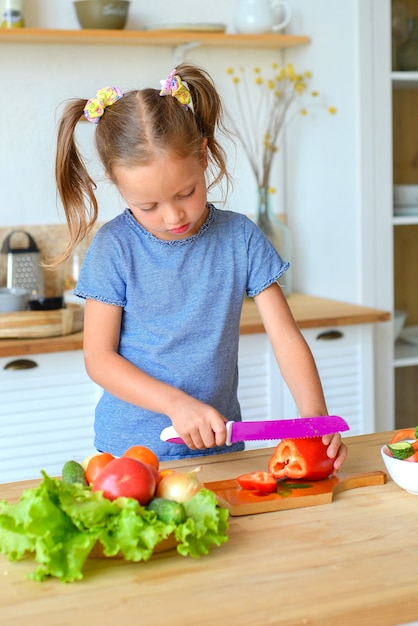 Adorable enfant cuisine dans la cuisine Jolie jolie fille prépare la soupe