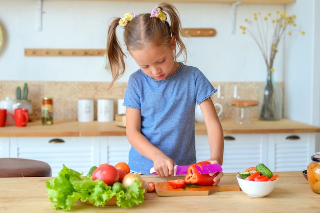 Adorable enfant cuisine dans la cuisine Jolie jolie fille prépare la soupe