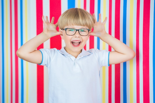 Adorable enfant sur fond coloré. Enfant mignon à l'intérieur en studio près du mur.