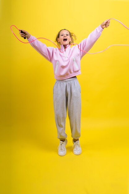 Adorable enfant de sexe féminin avec saut à la corde en studio