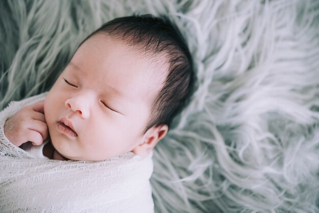 Adorable enveloppe de bébé nouveau-né par une serviette de lapin blanc