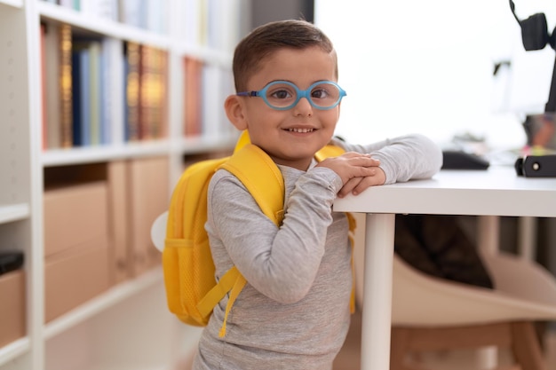 Adorable étudiant hispanique en bas âge souriant confiant debout à l'école de la bibliothèque