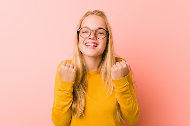 Adorable femme adolescente acclamant insouciante et excitée. Concept de victoire.