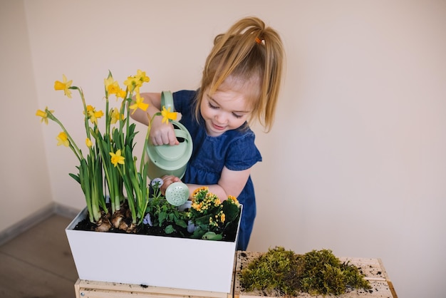 Adorable fille arrosant des fleurs avec arrosoir