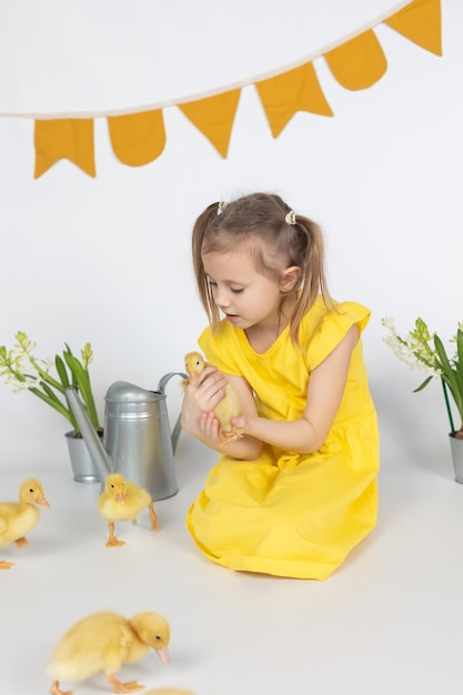 Adorable fille caucasienne d'âge scolaire tenant un mignon petit canard dans les mains