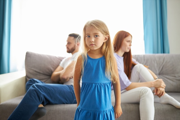 Adorable fille enfant caucasienne entre parents déprimés