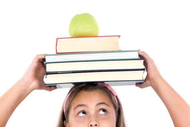 Adorable fille étudie avec des livres et pomme dans la tête