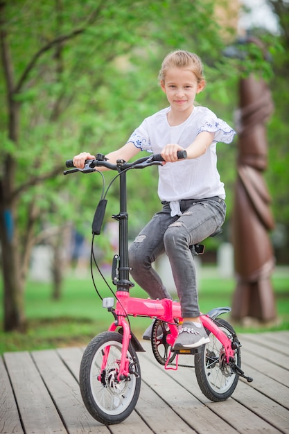 Adorable fille faire du vélo à la belle journée d'été en plein air